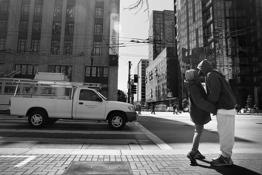 Shereese McIntosh (l to r) and Melvin Walker share a kiss as they stand on the corner of Market Street and Polk Street across from Twitter headquarters on their way to check out a SRO they might be moving to in the future  on Friday,  April 13,  2018, in  San Francisco, Calif.  McIntosh and Walker said they got help from the HOT team and Navigation Center before getting a spot in an n SRO a couple of weeks ago. Photo: Lea Suzuki / The Chronicle