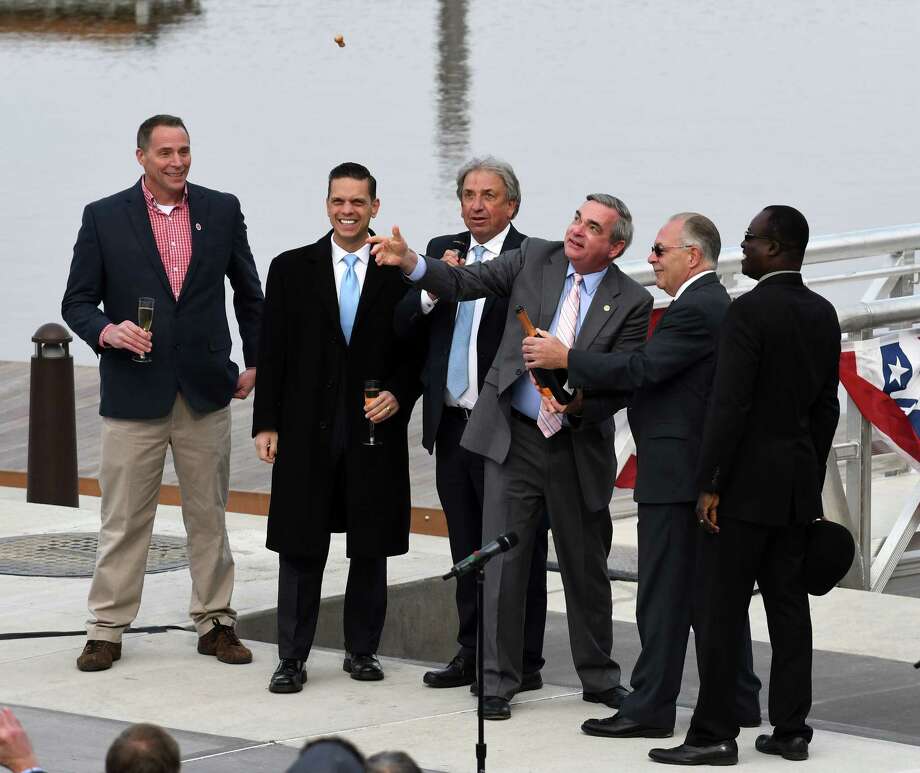 Assemblyman Angelo Santabarbara, second from left, David Buicko, president and CEO of the Galesi Group, and others, watch as Mayor Gary McCarthy, third from right, pops the cork on a bottle of bubbly during a ceremony to mark the completion of the marina at Mohawk Harbor on Wednesday, Nov. 1, 2017, in Schenectady, N.Y. The signature element of a $480 million mixed-use development is ready for public use and includes 50 boat slips, amphitheater, and kayak launch. (Will Waldron/Times Union) Photo: Will Waldron, Albany Times Union / 20042014A