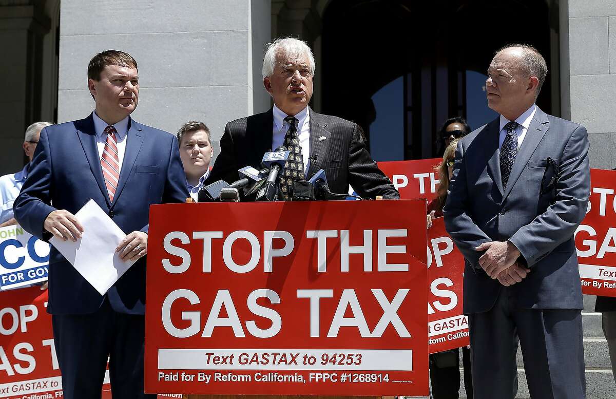 Republican gubernatorial candidate John Cox, center, blasts a recent gas tax increase during a news conference Monday, June 18, 2018, in Sacramento, Calif. Cox is the chairman of a campaign to repeal the gas tax increase and faces Democratic Lt. Gov. Gavin Newsom in November. Cox is flanked by Carl DeMaio, left, chairman of Reform California, and Jon Coupal, right, president of the Howard Jarvis Taxpayers Association. (AP Photo/Rich Pedroncelli)