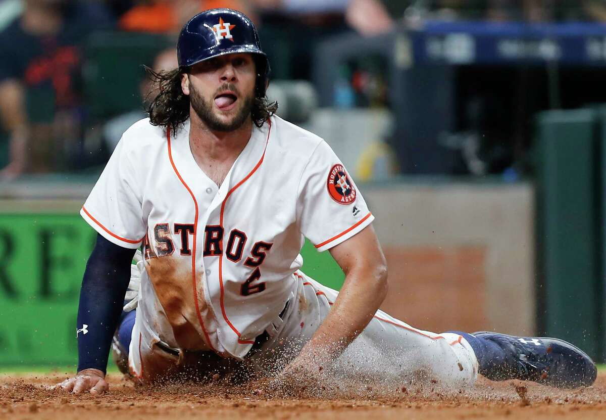 Houston Astros center fielder Jake Marisnick slides across the plate as he scores on an RBI single by Alex Bregman during the fourth inning against the Toronto Blue Jays in a major league baseball game at Minute Maid Park on Monday, June 25, 2018, in Houston.