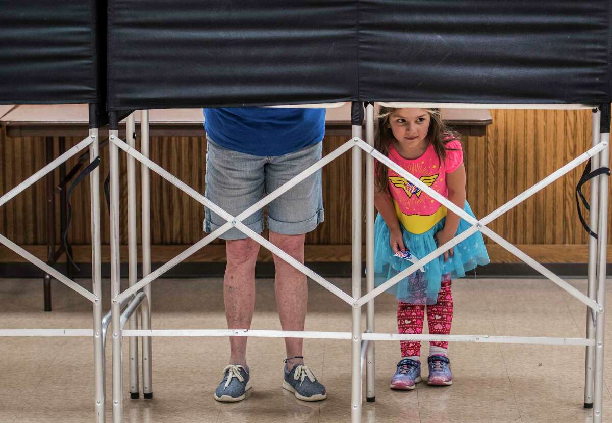 Chloe Day, 4 peers out from under the voting booths as her grandmother Nancy Marchione casts her ballot during the Democratic primary for the 19th Congressional District at the Brunswick #1 Fire Company firehouse Tuesday June 26, 2018 in Brunswick, N.Y. (Skip Dickstein/Times Union)