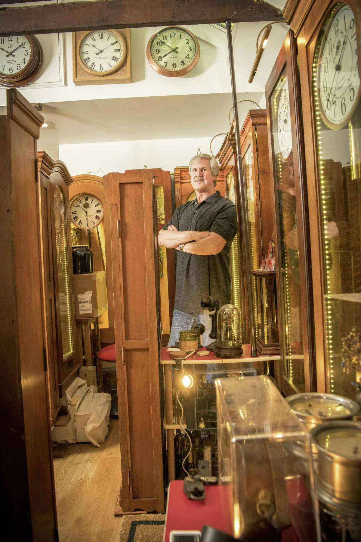 Dave Deitrich with some of his restore clocks in his tiny Stamford workshop.