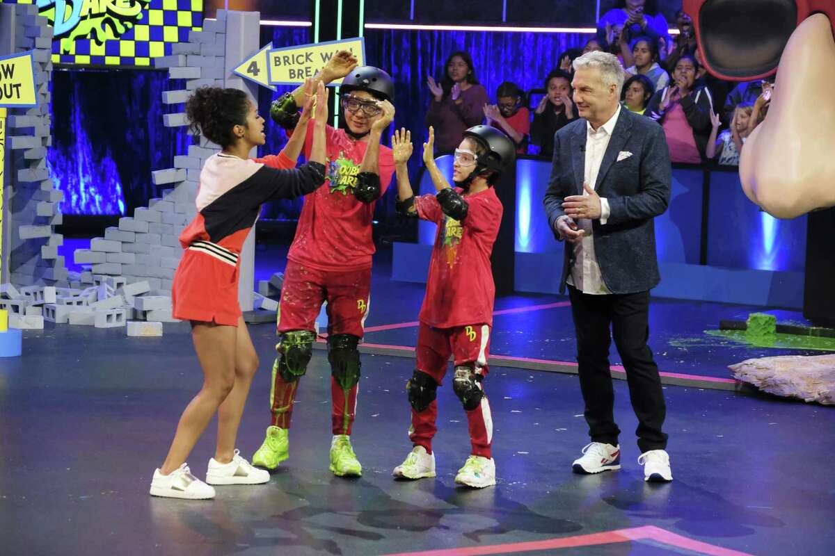 Liza Koshy (left) and Marc Summers (right) with contestants on the reboot of the game show “Double Dare,” which is returning to Nickelodeon.