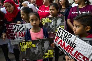 Children stand and hold protest signs during a rally in front of Federal Courthouse in Los Angeles on Tuesday, June 26, 2018. Immigrant-rights advocates asked a federal judge to order the release of parents separated from their children at the border, as demonstrators decrying the Trump administration's immigration crackdown were arrested Tuesday at a rally ahead of a Los Angeles appearance by Attorney General Jeff Sessions. (AP Photo/Richard Vogel)