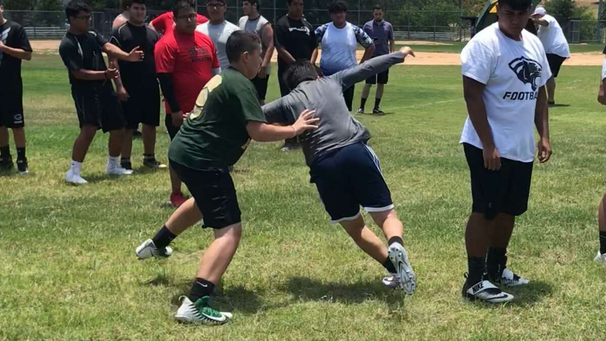 Jonathan Guzman (left) executes a drill at the Tip of the Spear lineman camp. Participants learned technique that is currently used by eight NFL teams.