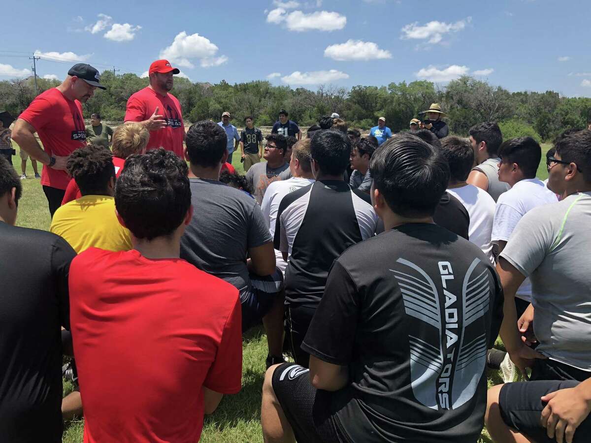 Former New York Giants lineman Scott Peters (red cap) talks to camp members at The Tip of the Spear lineman camp.