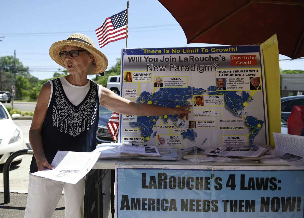 Judy Clark distributes information at the LaRouche PAC stand set up near the U.S. Post Office in the Cos Cob section of Greenwich, Conn. Tuesday, June 26, 2018. The political action committee, named after Lyndon LaRouche, asks to end the "coup" against President Trump, support China's One Belt One Road Initiative, and support LaRouche's economic policies reinstating the Glass?–Steagall banking separation act and returning to a national banking system.