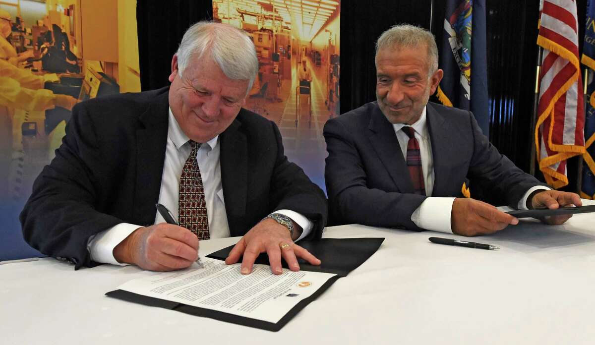 Ron Oakley, M+W CEO, left, signs an agreement with Dr. Alain E. Kaloyeros CEO of SUNY Polytechnic Institute after the announcement that M+W Group will expand its U.S. headquarters at the Albany Nanotech complex and outlines a new research alliance and $105 million statewide solar power initiative on Thursday, March 26, 2015, in Albany, N.Y. (Skip Dickstein/Times Union archive)