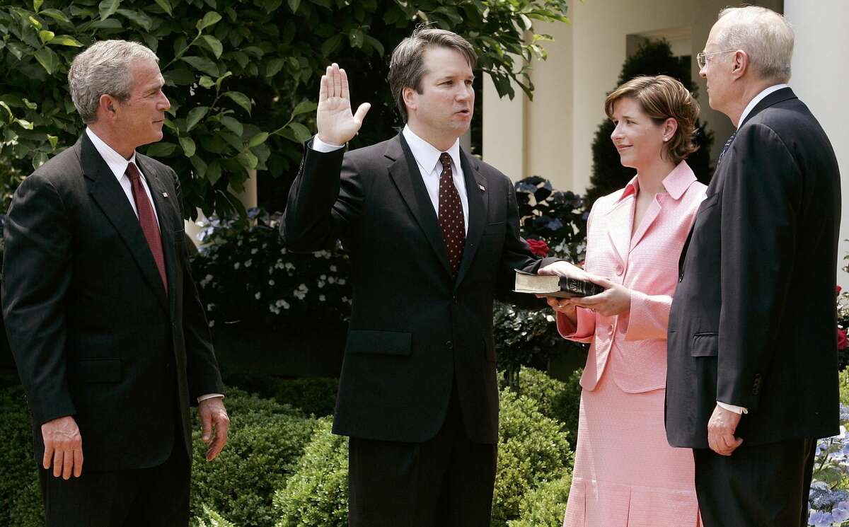 WASHINGTON - JUNE 01: (AFP OUT) Brett Kavanaugh (2nd L) is sworn in by Supreme Court Justice Anthony Kennedy (R) to be a judge to the U.S. Circuit Court of Appeals for the District of Columbia as his wife Ashley (2nd R) and U.S. President George W. Bush (L) look on during a swearing-in ceremony at the Rose Garden of the White House June 1, 2006 in Washington, DC. Kavanaugh was confirmed by the Senate with a vote of 57 to 36. (Photo by Alex Wong/Getty Images)
