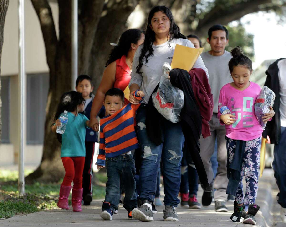 Immigrant families walk to a respite center after they were processed and released by U.S. Customs and Border Protection, Wednesday, June 27, 2018, in McAllen, Texas.