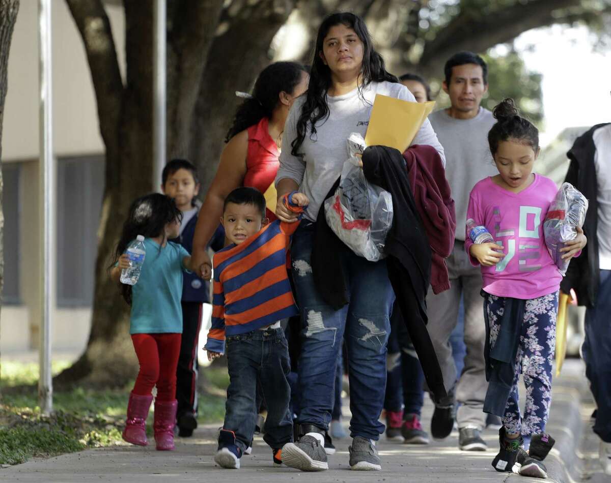 Immigrant families walk to a respite center after they were processed and released by U.S. Customs and Border Protection on Wednesday in McAllen. , Texas. (AP Photo/Eric Gay)