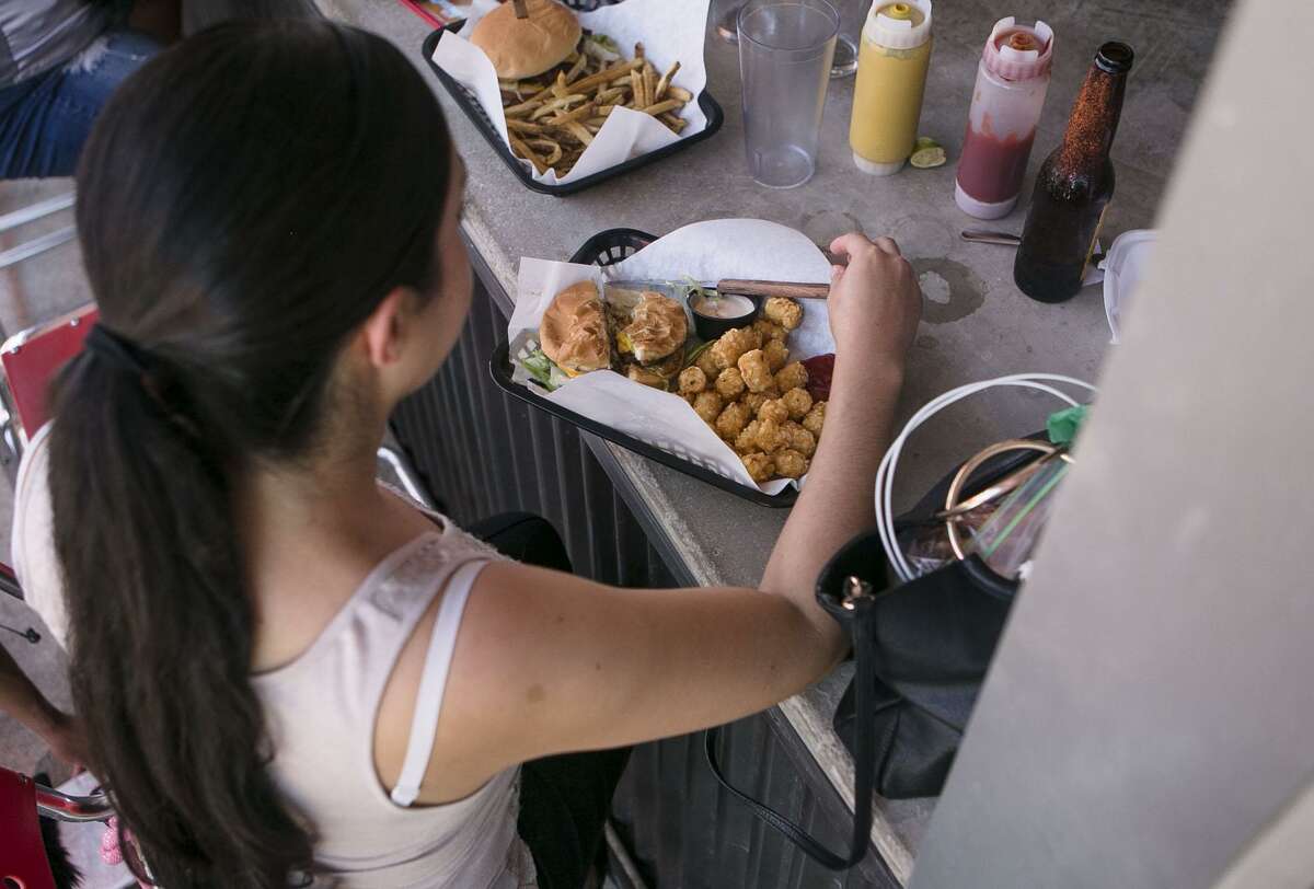 Rose Segura prepares to dig into her burger and tater tots at Luther's Cafe in San Antonio. Luther's Cafe is the winner of the San Antonio Express-News Readers' Choice of LGBTQ-Friendly Bar/Cafe.