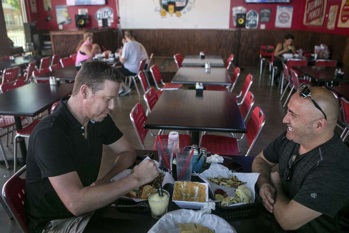 Jeff Moore (left) and Rick Ramos, right, share a joke over their meal at Luther's Cafe.