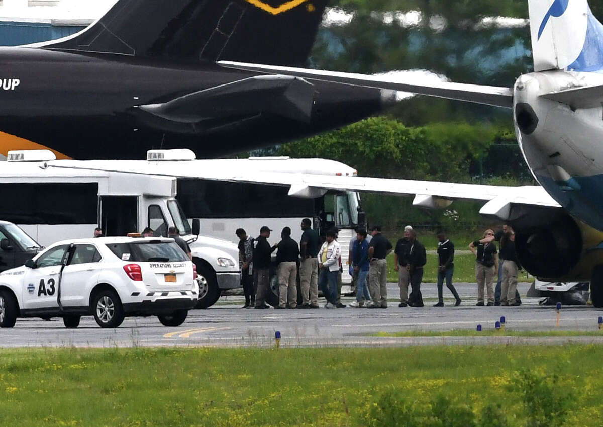 Immigrant men are escorted off a U.S. Immigration and Customs Enforcement jet from Arizona at Albany International Airport during their transport to Albany County jail on Thursday afternoon, June 28, 2018, in Colonie, N.Y. The jail has taken in 235 immigrant men who are being detained on immigration charges. None of them were separated from families according to jail officials. (Will Waldron/Times Union)