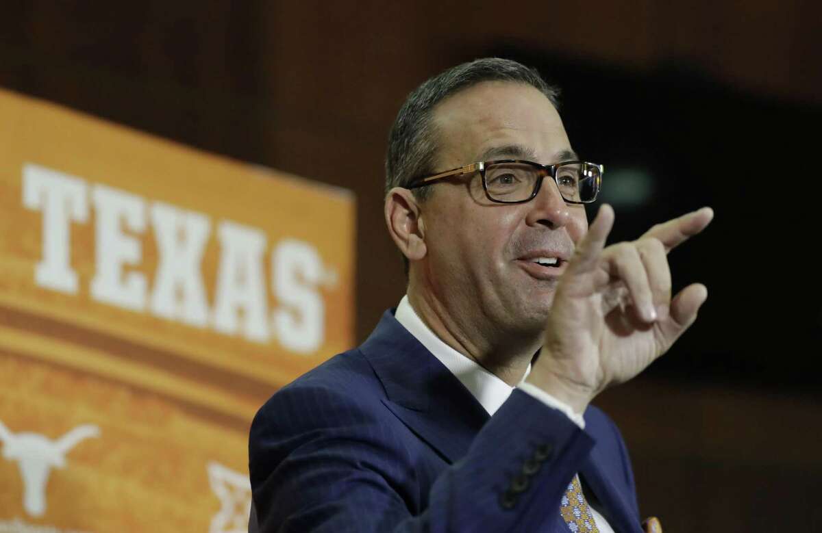 Chris Del Conte wiggles the Hook'em sign as he speaks during a news conference where he was introduced at the new vice president and athletics director for the University of Texas, Monday, Dec. 11, 2017, in Austin, Texas. (AP Photo/Eric Gay)