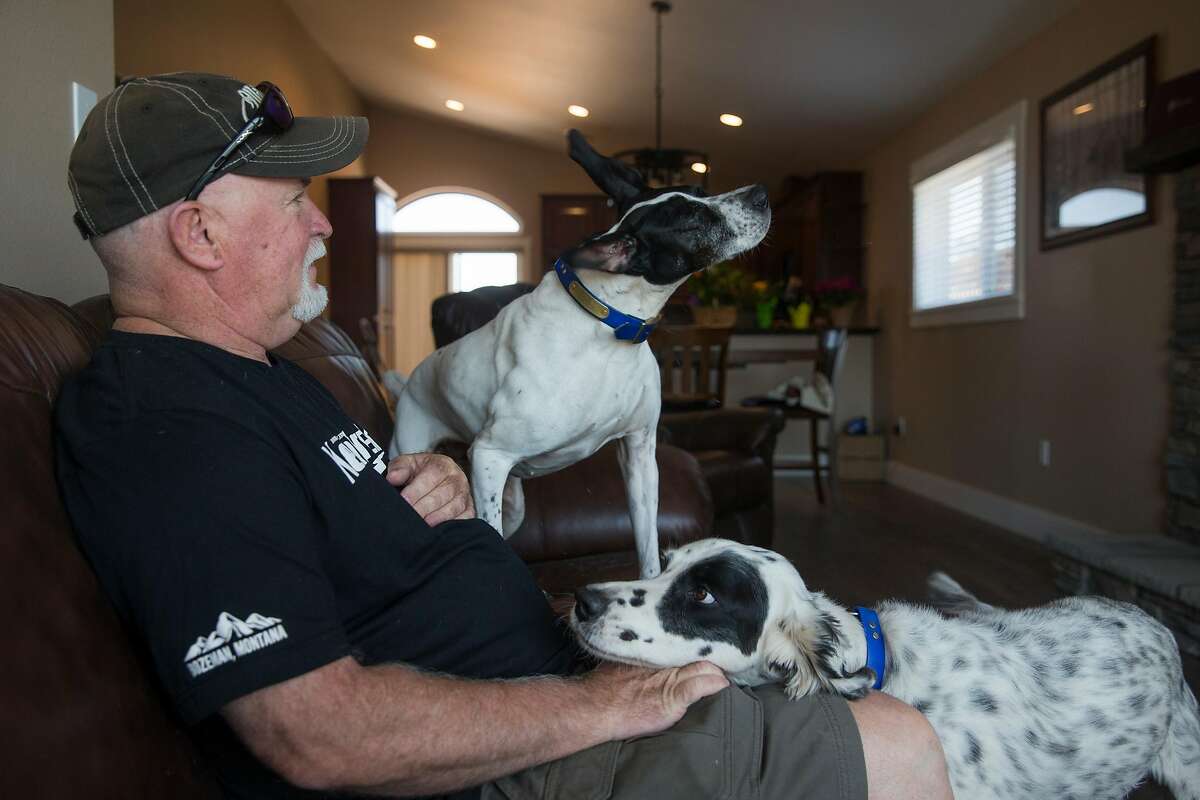 Dan Bradford sits with his two dogs in the living room of his newly constructed home built on the site of his former home that was destroyed during the Tubbs Fire in October 2017 in the Coffey Park neighborhood of Santa Rosa, Calif. Friday, June 8, 2018.