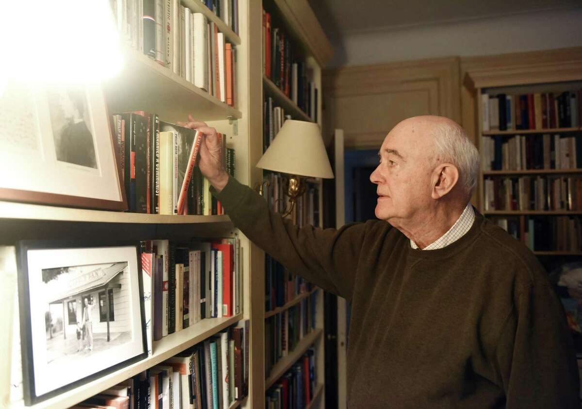 Former publisher of the Greenwich Time and Stamford Advocate Steve Isenberg looks through books in the library of his Upper West Side home during a recording for the new Rally podcast in New York, N.Y. Wednesday, April 25, 2018. Hearst Connecticut Media business reporter Macaela Bennett is recording and producing a new podcast in which business people describe the challenges they've encountered in their rise to success.