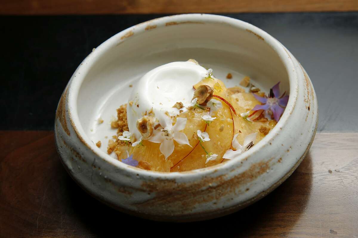 The frozen yogurt with peach, hazelnut and coconut caramel at Sorrel, Tuesday, June 19, 2018, in San Francisco, Calif.