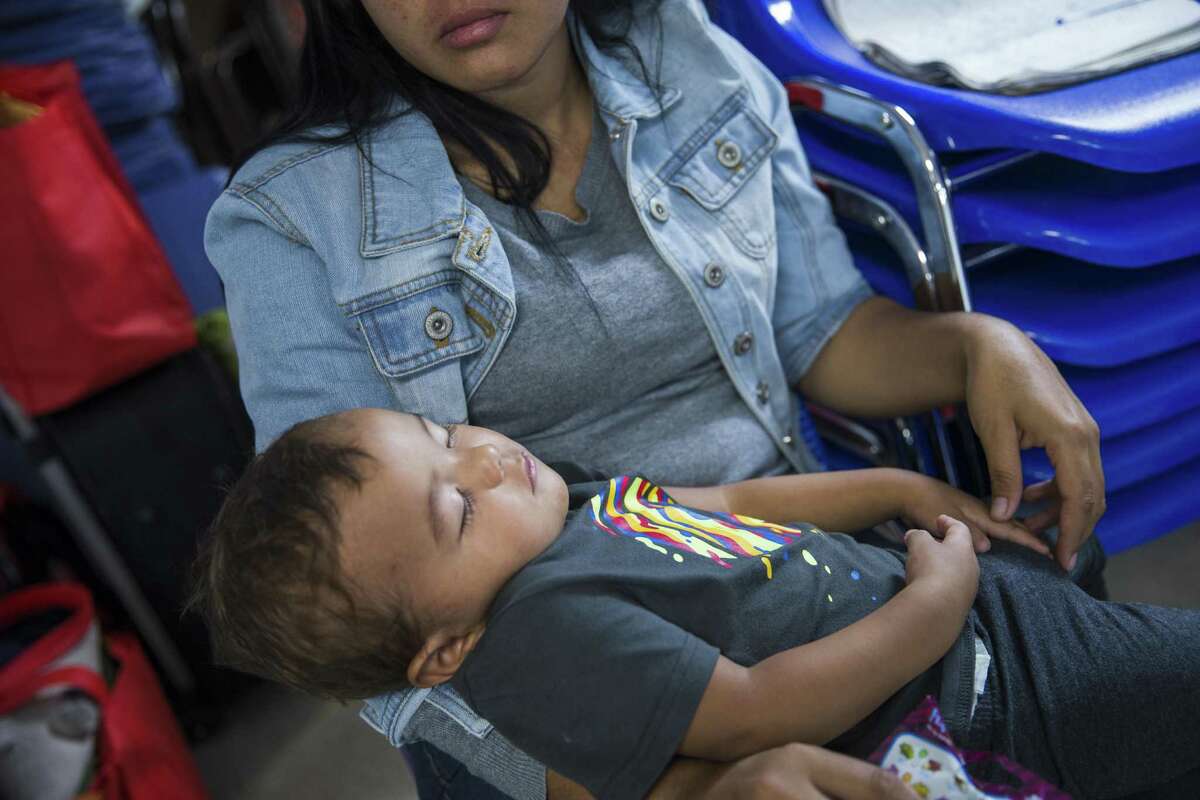In a Thursday, June 21, 2018 photo, Jennifer holds her son, Jayden, 10-months, at the Catholic Charities Humanitarian Respite Center, in McAllen, Texas. Jennifer and her son recently arrived in the USA from Nicaragua and were not amongst the families charged and separated upon crossing the border. The center provides aid to families in crisis, offering clean clothes, a shower and meal before they embark to their final destinations. (Amanda Voisard/Austin American-Statesman via AP)