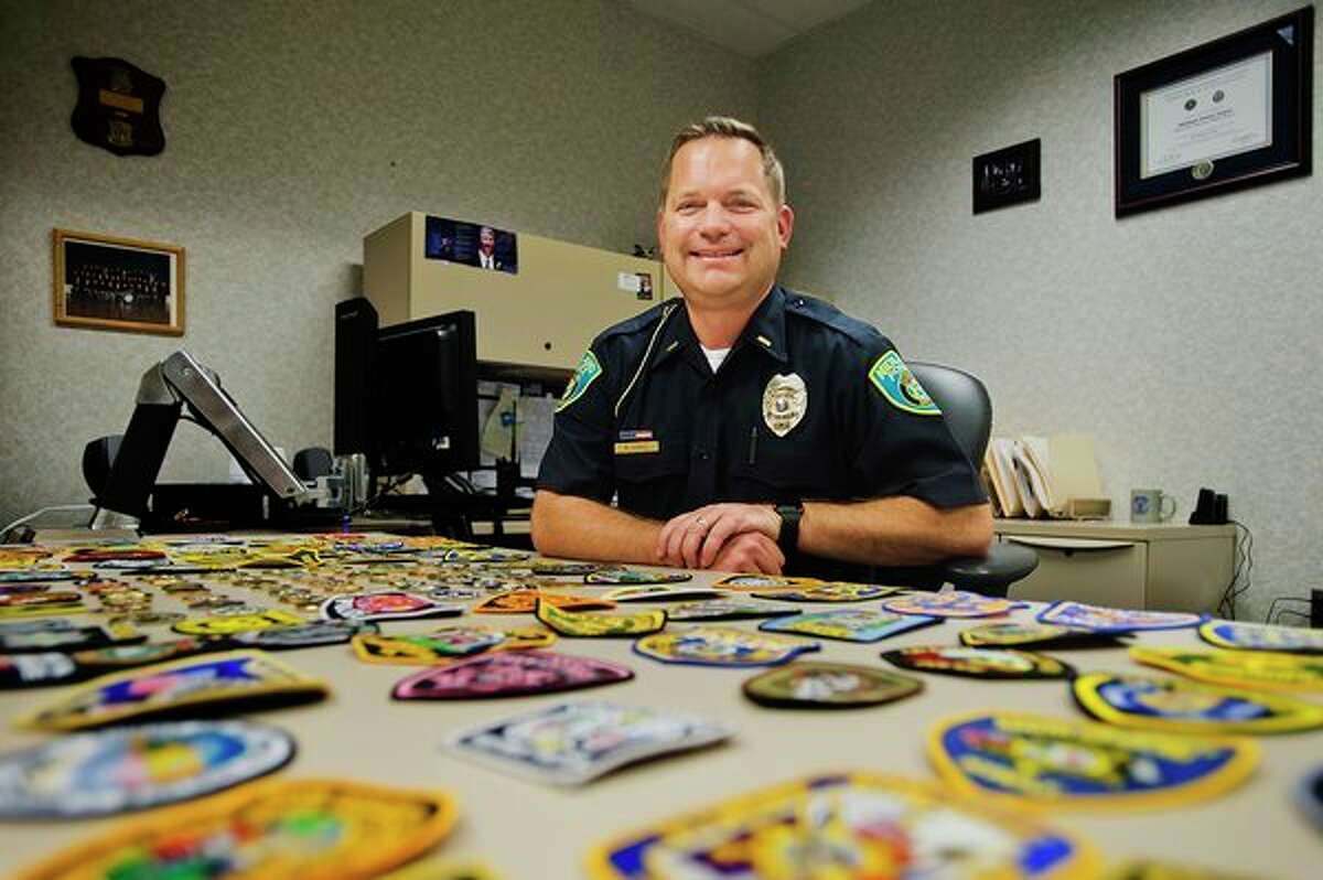 Lt. Mike Sokol of the Midland Police Department poses for a portrait with some of the patches he traded for with fellow graduates of this year's FBI National Academy Program in Quantico, Virginia. (Katy Kildee/kkildee@mdn.net)