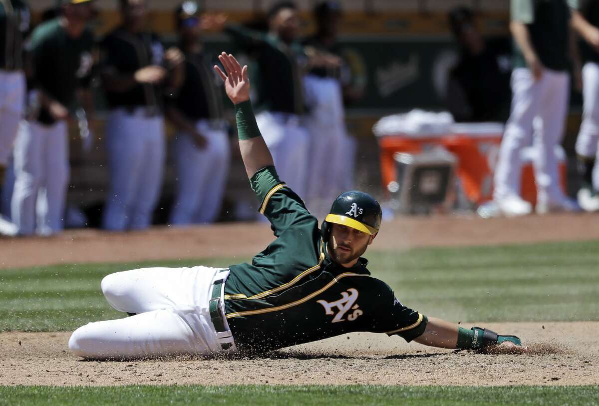 Oakland Athletics' Dustin Fowler scores on a a double by Mark Canha during the sixth inning of a baseball game against the Cleveland Indians, Saturday, June 30, 2018, in Oakland, Calif. (AP Photo/Marcio Jose Sanchez)