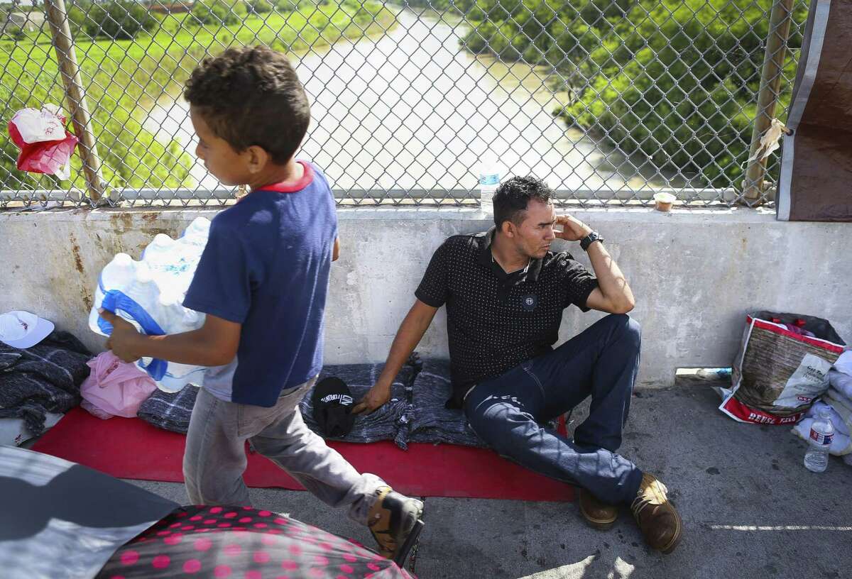 Walter Bindel, from Honduras, sits on the Mexican side of the middle of the Brownsville & Matamoros Express International Bridge for the fourth day in a row hoping for his family to be able to pass together into the United States to seek asylum, Wednesday, June 27, 2018 in Brownsville. Walter, his wife and four children are hoping to escape violence threats against them in their hometown in Honduras. ( Mark Mulligan / Houston Chronicle )