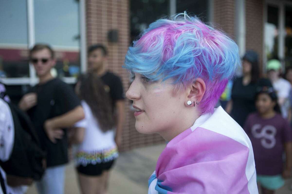 Max Pohlmeier poses draped in a transgender pride flag at the annual Pride San Antonio festival held at Crockett Park June 30, 2018.