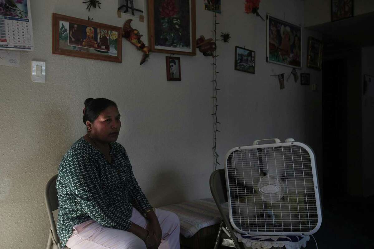 Battle Mya Bhujel sits by a fan with the door open on the second floor of her apartment complex because her air conditioning has been broken for months, along with the lock on their door. She said that even after multiple complains made to the management, they keep saying “we will do it tomorrow.”