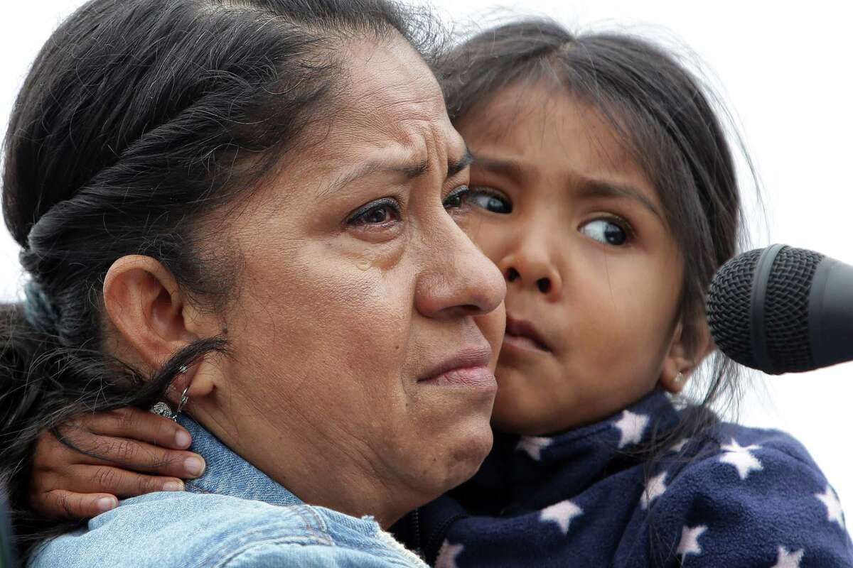 Silvia Gonzalez, of Casa Latina, holds her four-year-old granddaughter as she speaks to a crowd of several thousand demonstrators gathered outside the Federal Detention Center in SeaTac to protest the separation of families crossing the southern border and the Trump administration's immigration policies as part of a nationwide Families Belong Together day of action, June 30, 2018.