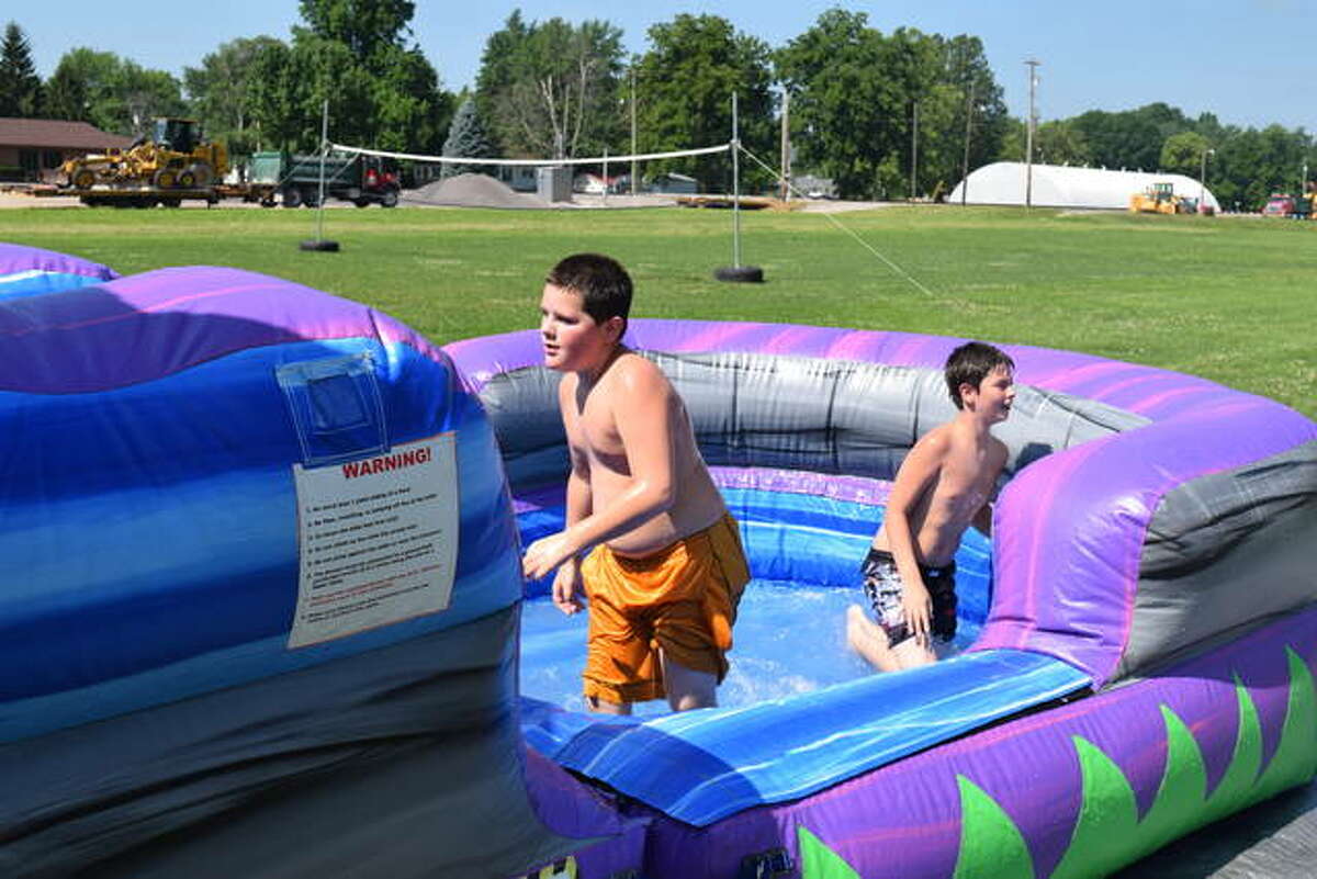 Two unidentified boys play on an inflatable water slide Saturday at Faith Tabernacle Church in Jacksonville. The church celebrated its 60th anniversary with a Summer Fun Fest. There also was a bounce house, dunk tank, food, games and a yard sale.