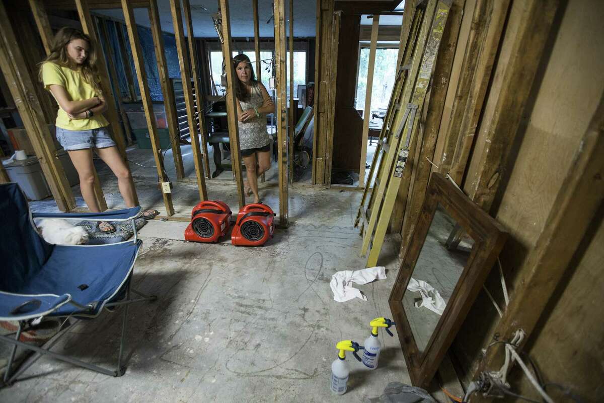 Clair Slaughter and her mother, Amy, stand inside their flood-damaged home, with the flood line seen on the wall to the right, as they rebuild, on Thursday, June 28, 2018, in Kingwood. The Slaughters are in favor of a project to dredge a large sandbar in the San Jacinto River, to help alleviate flooding in Kingwood. They are still recovering from the floodwaters from Hurricane Harvey, where they had 52 inches of water inside their home.