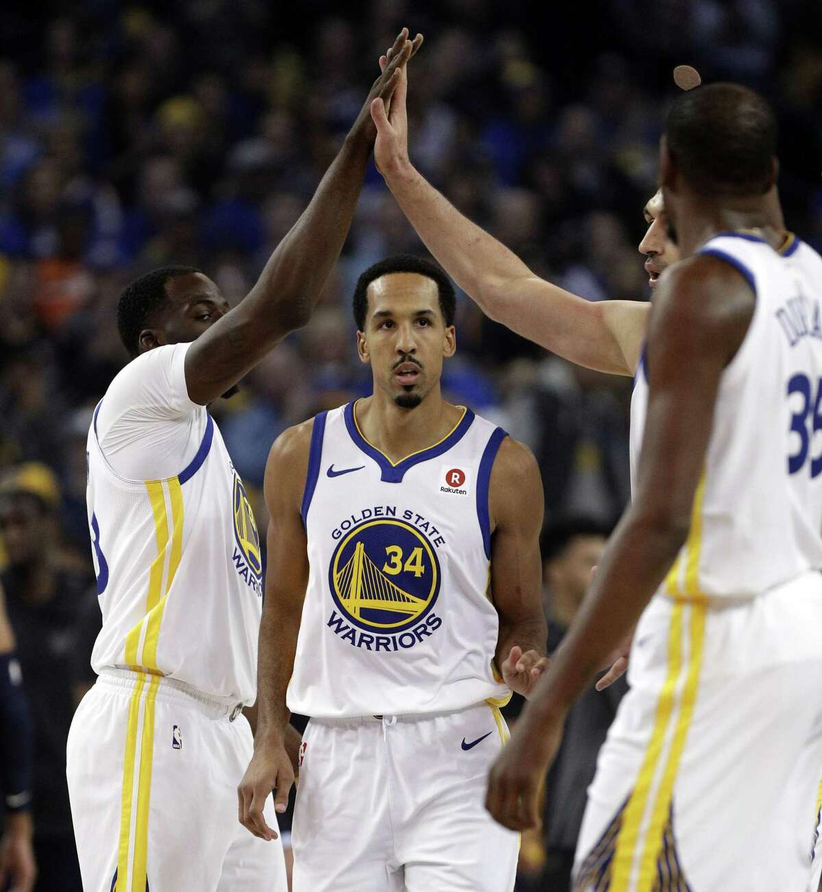 The Warriors high five after a scoring play for Shaun Livingston (34) in the first half as the Golden State Warriors played the Utah Jazz at Oracle Arena in Oakland, Calif., on Wednesday, December 27, 2017.
