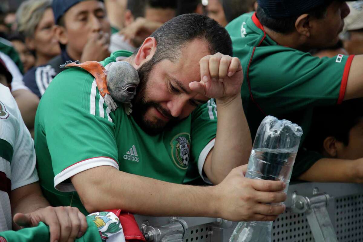 A Mexico soccer fans reacts to Brazil's goal during a live broadcast of the Russia World Cup game in Mexico City's Zocalo plaza, Monday, July 2, 2018. (AP Photo/Anthony Vazquez)