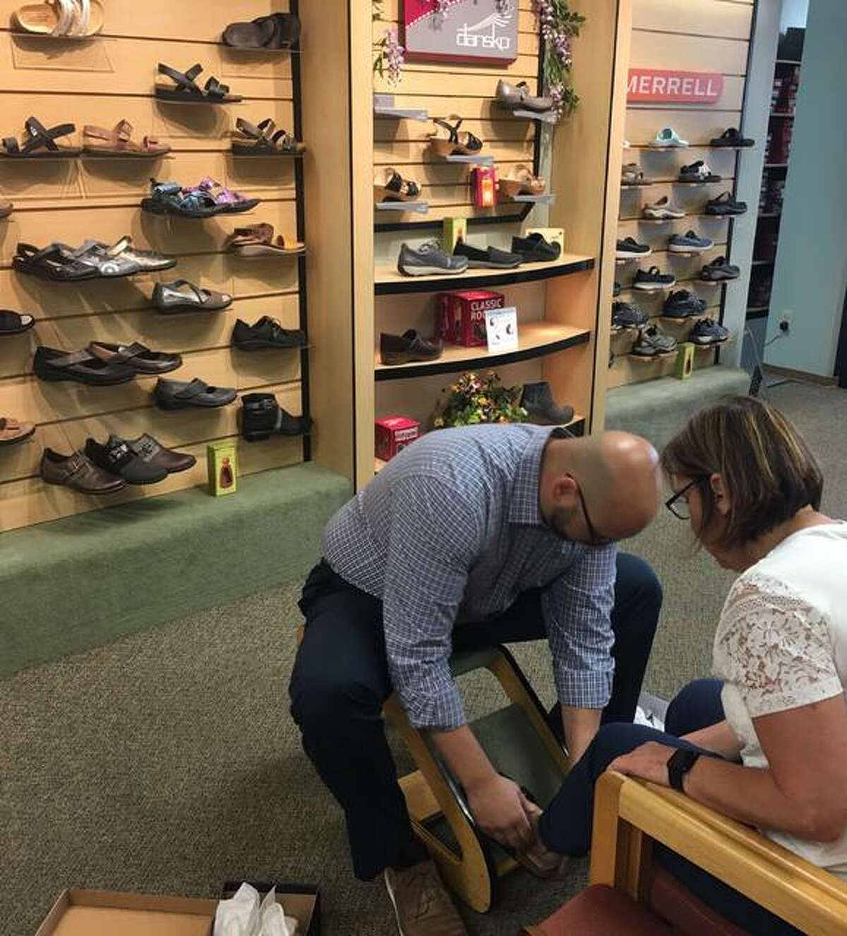 Cleary’s Shoes & Boots new owner, Andrew Hagopian, a certified pedorthist, fits customer Alana Yount for new summer shoes.