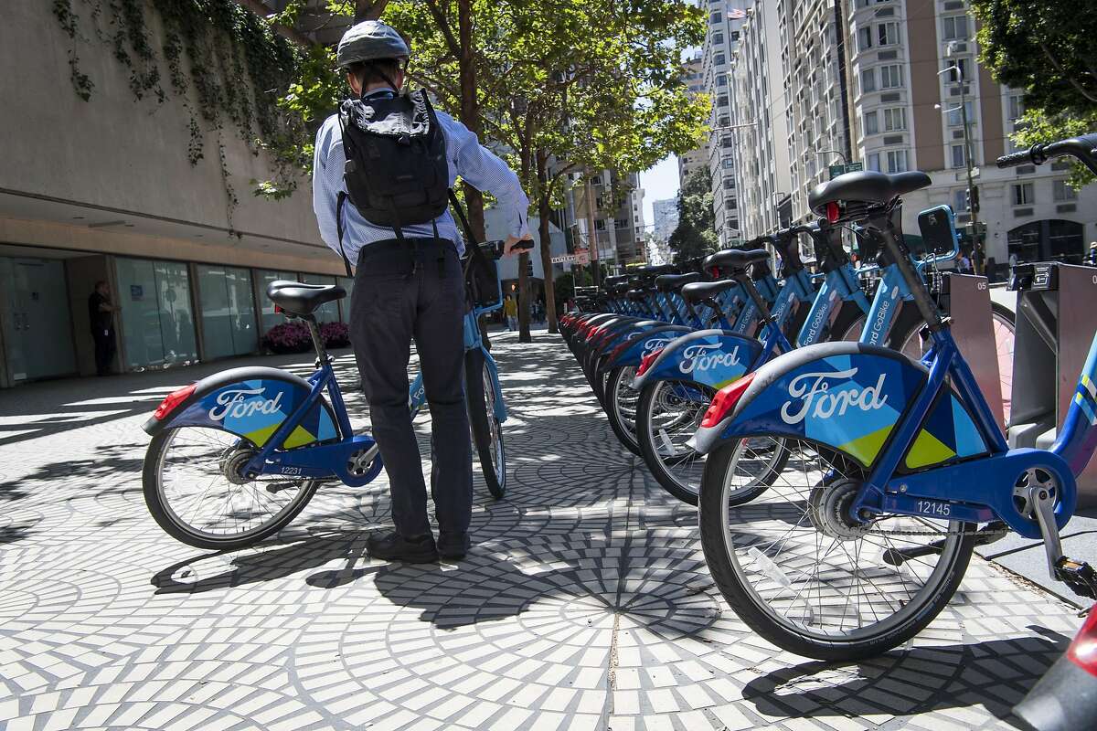 A pedestrian prepares to ride a Ford GoBike in San Francisco, California, U.S., on Monday, June 11, 2018. Lyft Inc. is in discussions to acquire Ford GoBike and Citi Bike operator Motivate for $250 million, a person familiar with the matter said. The acquisition, if it goes through, would thrust the second-largest U.S. ride-hailing company into the middle of the brewing war over electric scooters and bikes that's beginning to roil American cities. Photographer: David Paul Morris/Bloomberg