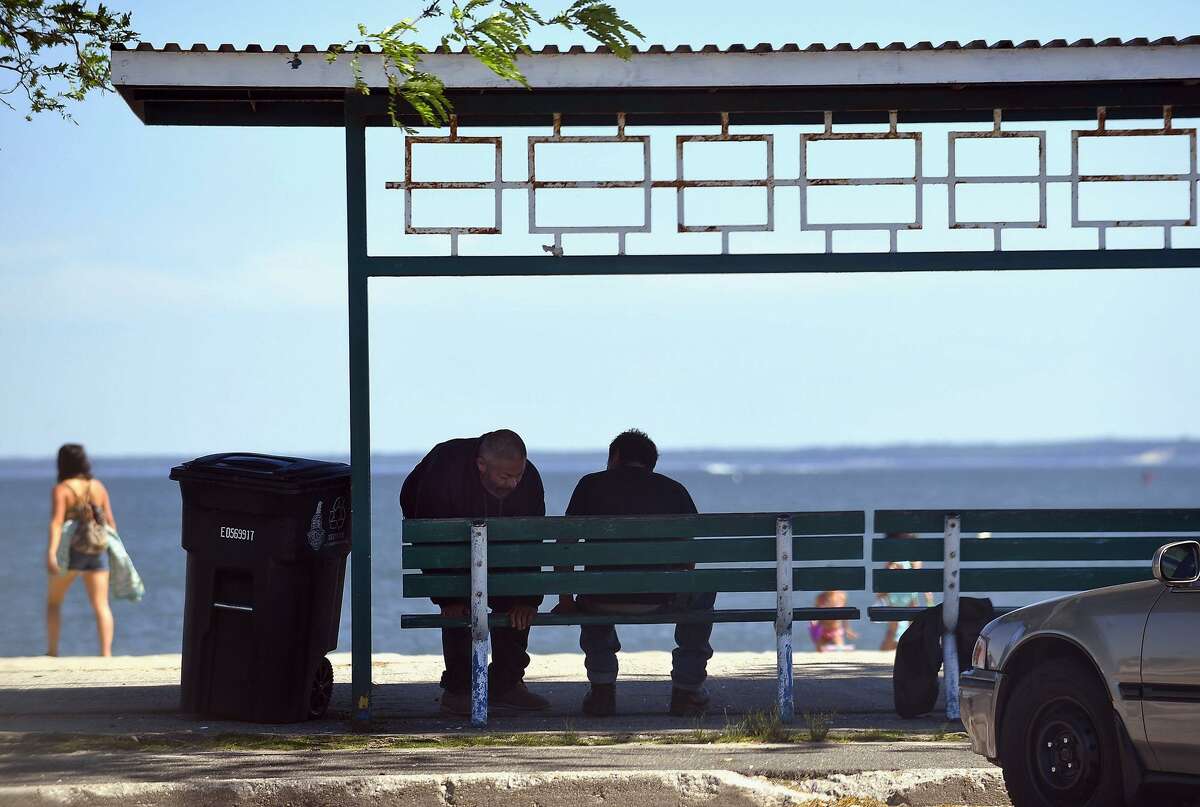 In this June 19, 2018, photo, two individuals have conversation on a park bench at Cummings Beach Park in Stamford. After months of discussion about the fate of the city’s park police amid growing concerns about a lack of security in public parks, the officers were sworn in the day before their appointments were to expire.