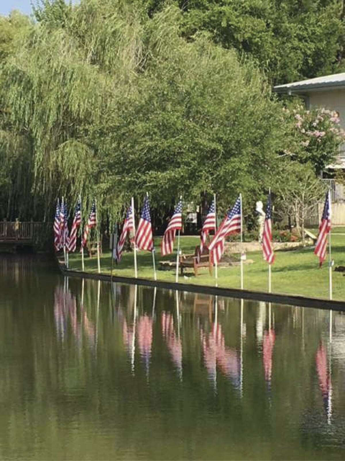 Flags surround the pond at Memory Park for the 4th of July holiday.