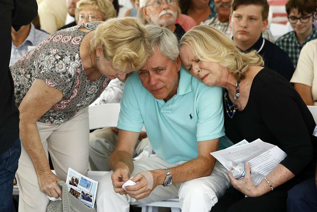 CORRECTS TO REMOVE ID OF WOMAN AT LEFT, AS SHE IS UNIDENTIFIED - Carl Hiaasen, center, brother of Rob Hiaasen, one of the journalists killed in the shooting at The Capital Gazette newspaper offices, is consoled by his sister Judy, right, and an unidentified mourner during a memorial service, Monday, July 2, 2018, in Owings Mills, Md. (AP Photo/Patrick Semansky)