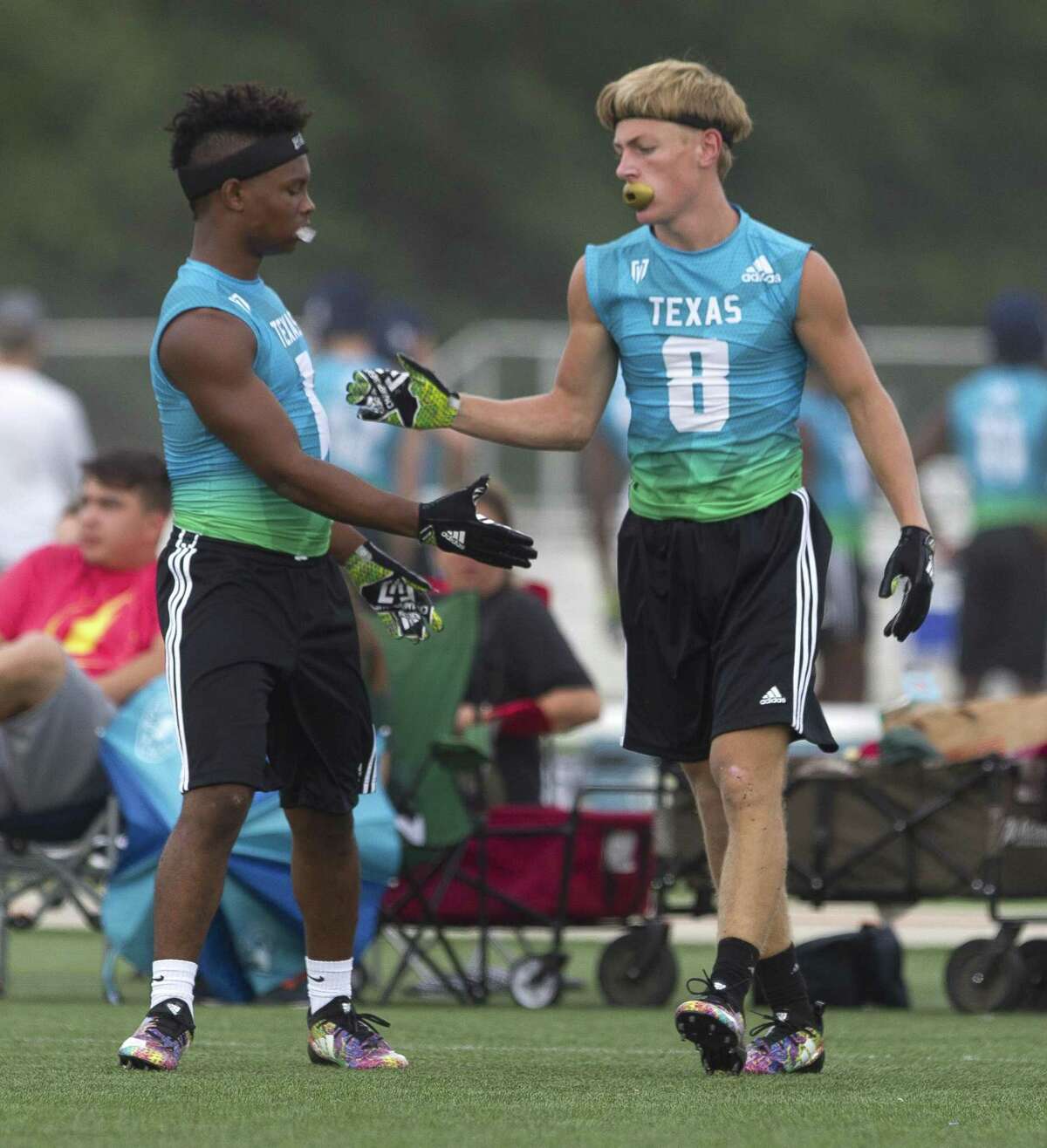 The Woodlands’ Austin Winfield (1) gives teammate Abb Acuff (8) a high-five after breaking up a pass during a game at the 7-on-7 state tournament at Veterans Park and Athletic Complex on Saturday in College Station.