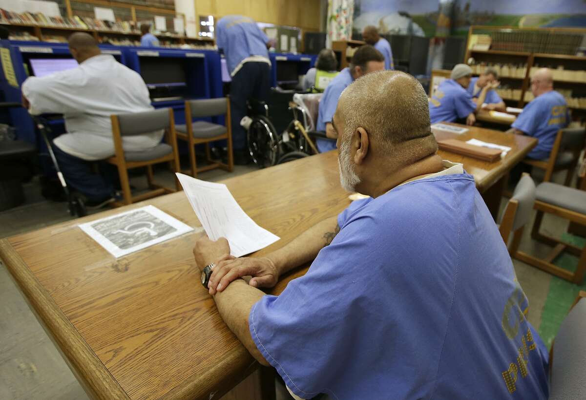 In this photo taken June 20, 2018, inmates use the library at the California Medical Facility in Vacaville, Calif. CMF is one of the California prisons where general population inmates are expected to peacefully co-exist alongside inmates formerly housed on so-called Sensitive Needs Yards. The protective yards were created to safeguard gang snitches, disgraced cops, child molesters and others in need of protective custody. But they have become so violent and crowded that officials are dismantling the program. (AP Photo/Rich Pedroncelli)