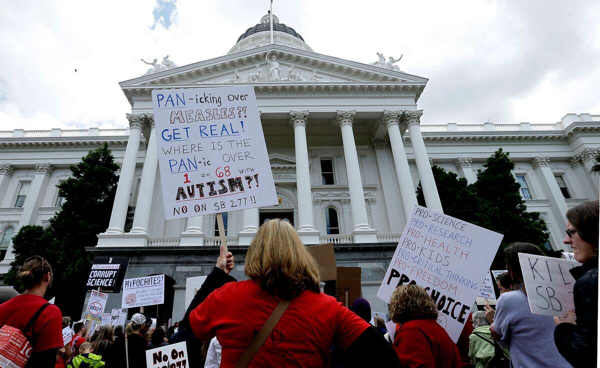 Kelly Trutter, back to camera, joined others protesting against a measure requiring California schoolchildren to get vaccinated, at a Capitol rally in Sacramento, Calif., Wednesday, April 8, 2015. The bill SB277 by Sen. Richard Pan, D-Sacramento, and Sen. Ben Allen, D-Santa Monica, will be heard by the California Senate Health committee Wednesday. If approved by the Legislature and signed by the governor, parents could no longer cite personal beliefs or religious reasons to send unvaccinated children to private and public schools unless a child�s health is in danger. (AP Photo/Rich Pedroncelli)