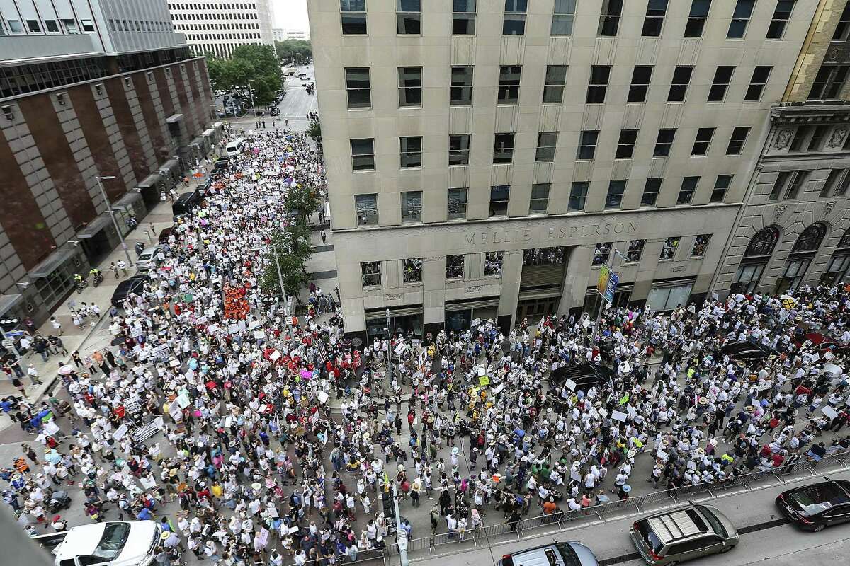 Protestors fill Walker and Travis Streets in Houston as they make their way to U.S. Sen. Ted Cruz's office during an immigration rally on Saturday, June 30, 2018. Rallies were held across the nation calling on federal agencies to reunite families separated at the border under Trump's "zero tolerance" policy, as well as calling for the abolishment of ICE. (Elizabeth Conley/Houston Chronicle via AP)