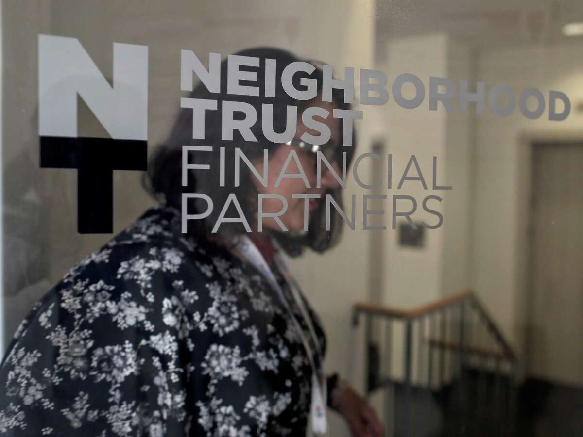 In this May 24, 2018, file photo, Rosa Franco, director of lending at Neighborhood Trust Federal Credit Union walks out of the bank to head upstairs to the offices of one of their financial partners in New York. Franco says the credit union's partnership with Finhabits still in development and she anticipates a challenge in marketing the service to her clients, many of whom are consumed by pressing concerns like debt repayment and or sending money to relatives abroad.