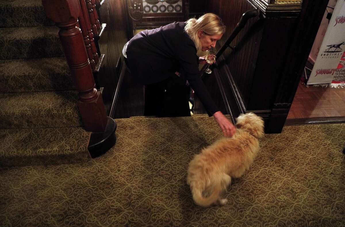 Visitor Heidi Knodle pets Fred the dog at the William Westerfeld House in San Francisco that is the setting for “Snaggletooth,” a new horror-comedy short by Colin Bishopp.