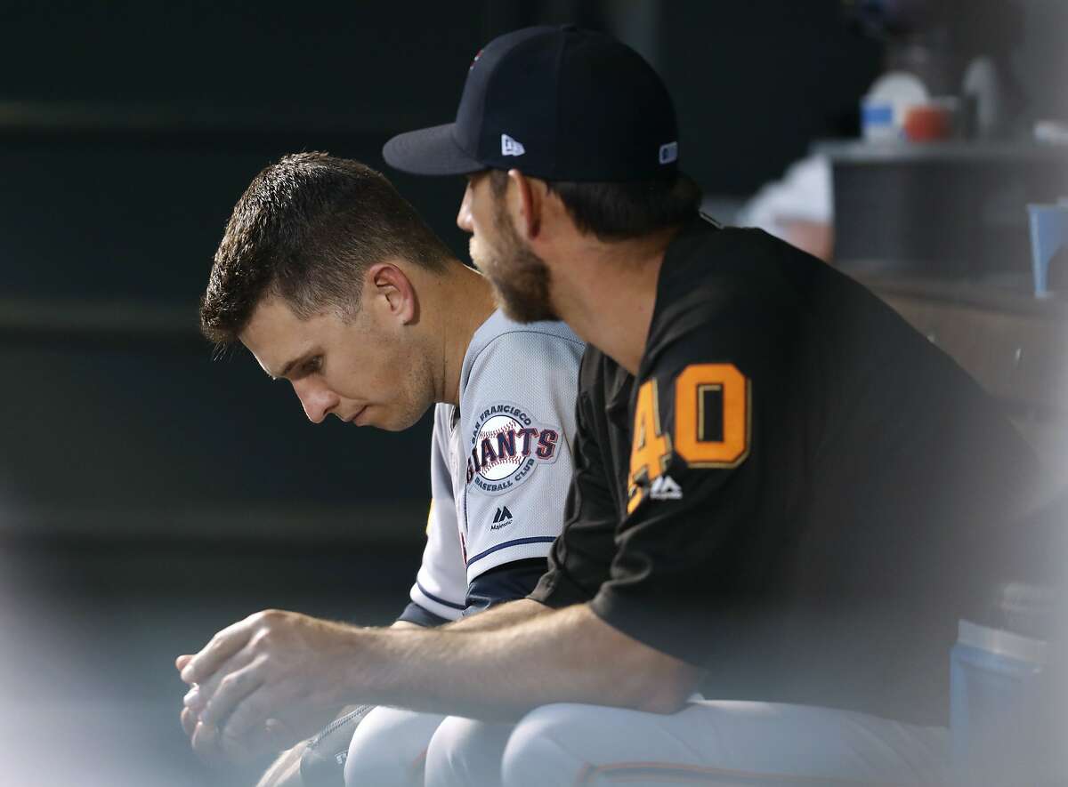 San Francisco Giants catcher Buster Posey, left, sits in the dugout with starting pitcher Madison Bumgarner in the seventh inning of the team's baseball game against the Colorado Rockies on Tuesday, July 3, 2018, in Denver.(AP Photo/David Zalubowski)