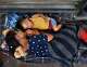 July 2, 2018 - Brownsville, Texas - Asylum seekers sleep on B/M Gateway bridge waiting to cross into U.S. from Mexico side. Ingrid Perdomo, 18 and her 1-year-old son Jose Luis take a nap in blistering heat. She came with her companion Luis Miguel, 32 from Honduras where they made the difficult 3 month journey. He said he fled in fear and cries a lot with anxiety about losing his past. His ex-wife started dating a gang member and the gang torched his home killing his 2 children inside. He fled to mountains seeking safety where he met Ingrid and they had another child. When they first arrived they said they were told by border guards they would not get in until their child was an adult, possibly as a deterrent then went to stay with a cousin in Mexico for a few days but had kidnap threats and returned to bridge July 1. They were eventually allowed in late on July 2 to be processed for credible fear. If not for a small humanitarian group Asociacion Civil Ayudandoles a Triunfar a.c. run by Glady Canas from Mexico they would have not had blankets to sleep on, food, water, etc. Carol Guzy/for San Antonio Express-News