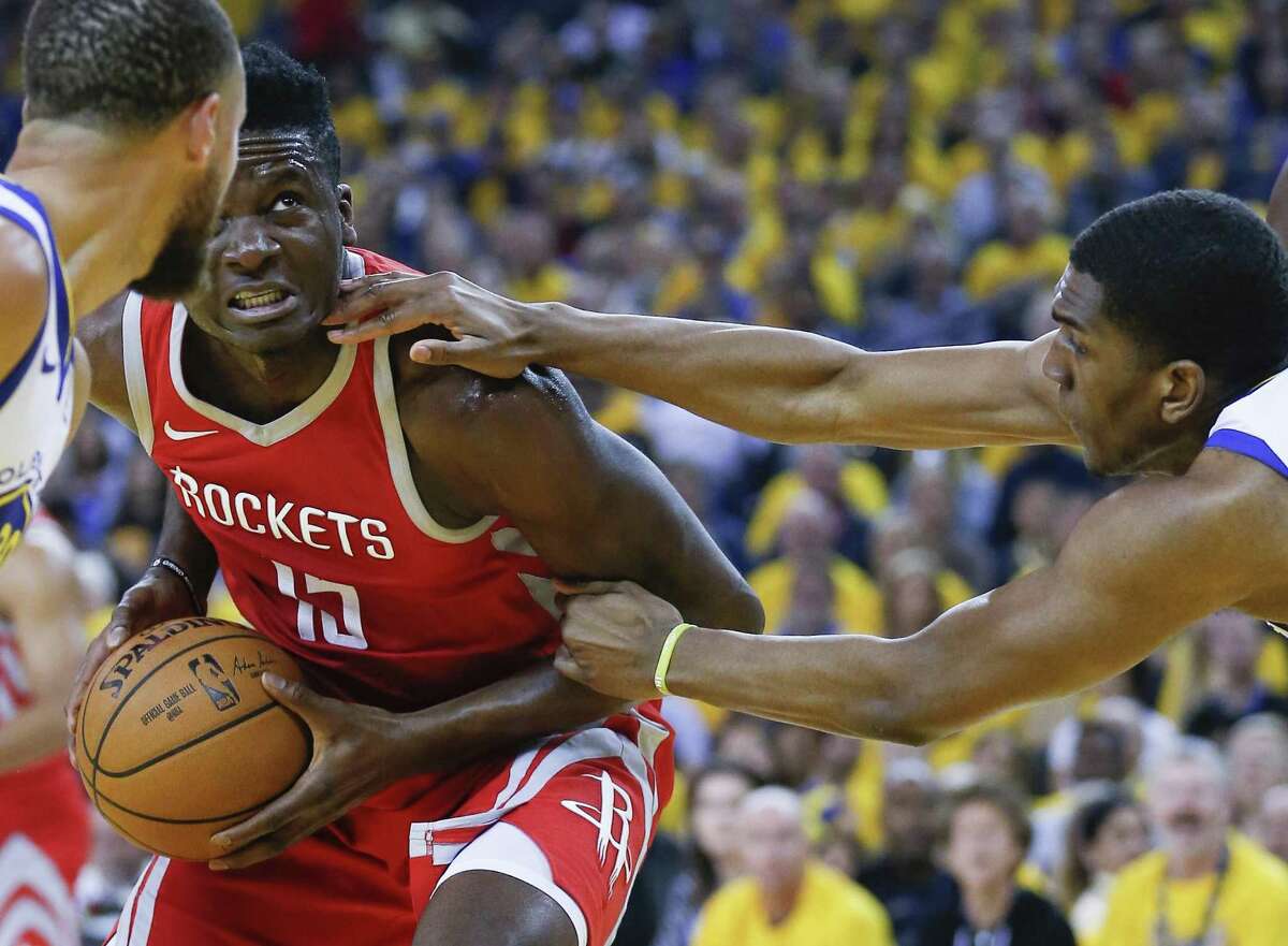 Clint Capela, left, being hounded by Warriors forward Kevon Looney, is a restricted free agent, meaning the Rockets can match any offer he receives from another team.