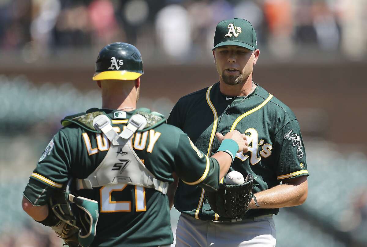 Oakland Athletics relief pitcher Blake Treinen receives the game ball from catcher Jonathan Lucroy after the ninth inning of a baseball game against the Detroit Tigers, Thursday, June 28, 2018, in Detroit. (AP Photo/Carlos Osorio)