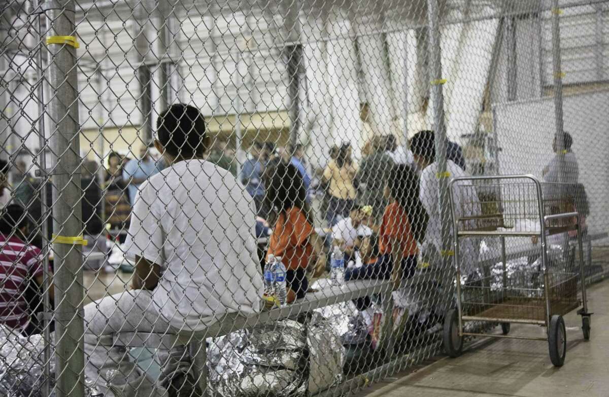 In this photo provided by U.S. Customs and Border Protection, people who've been taken into custody related to cases of illegal entry into the United States, sit in one of the cages at a facility in McAllen.