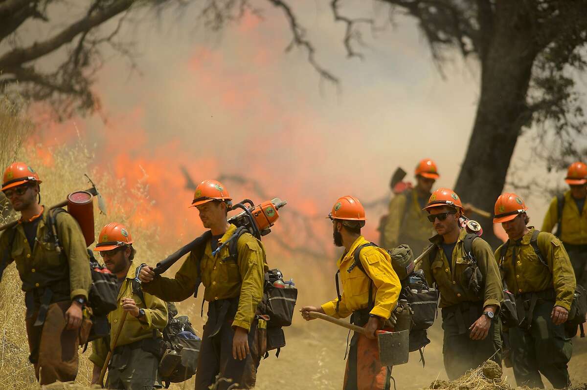 Hot Shot crews from Mendocino use backfires to help contain the County Fire along Highway 129 near Lake Berryessa in Yolo County, California, on Tuesday, July 3, 2018. 